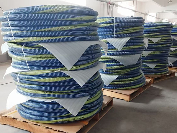 Packaged blue composite hose stacked on wooden pallet