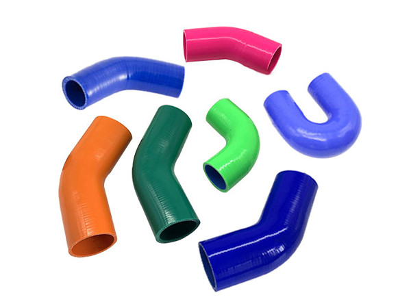 7 different colorful elbow silicone hoses on a white background