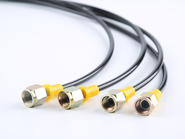 Four black fiber reinforced nylon resin hoses placed on a flat surface