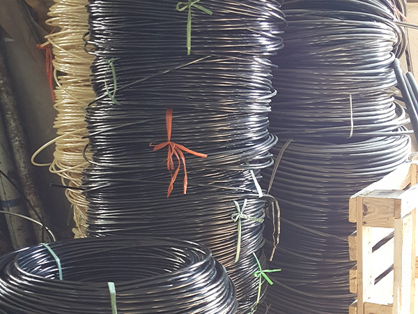 Several rolls of black fiber reinforced nylon resin hoses placed on the ground