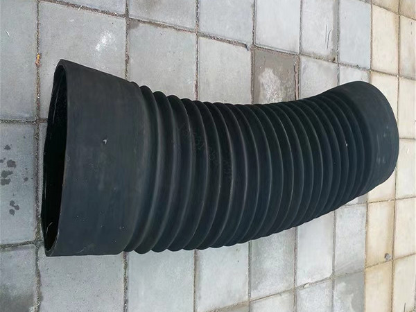 A large diameter rubber flexible air duct hose placed on the ground